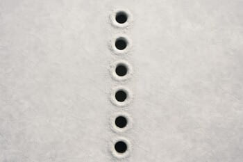 Ряд лунок на льду, уходящих по диагонали в сторону глубины