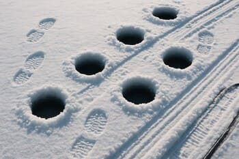 Ритмичные следы шагов на льду, уходящие к центру водоёма